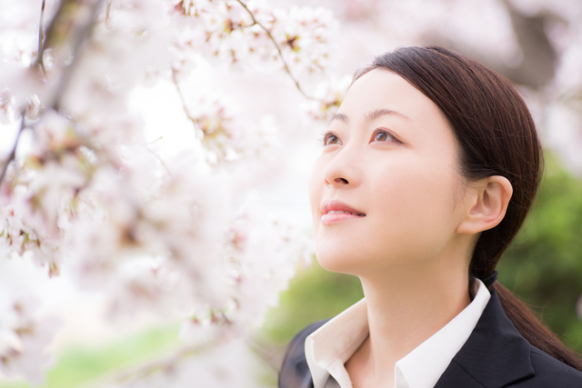 桜とスーツ姿の女性