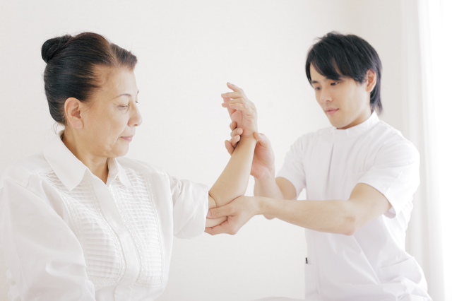 リハビリサポートをしている施術着を着た男性