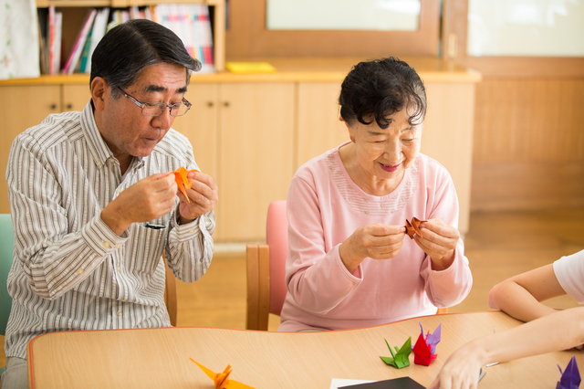 折り紙をしている高齢の男女